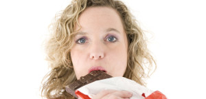 Young blond woman eats chocolate