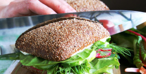 Housewife divides healthy rye bread sandwich in half